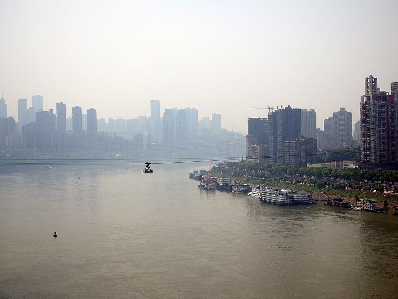 Chongqing Yangtze River Cableway car gliding high above the wide river between city skyscrapers