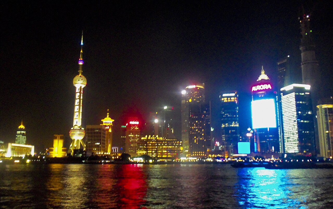 Illuminated Lujiazui skyscrapers and Oriental Pearl Tower seen across the Huangpu River from the Bund in Shanghai