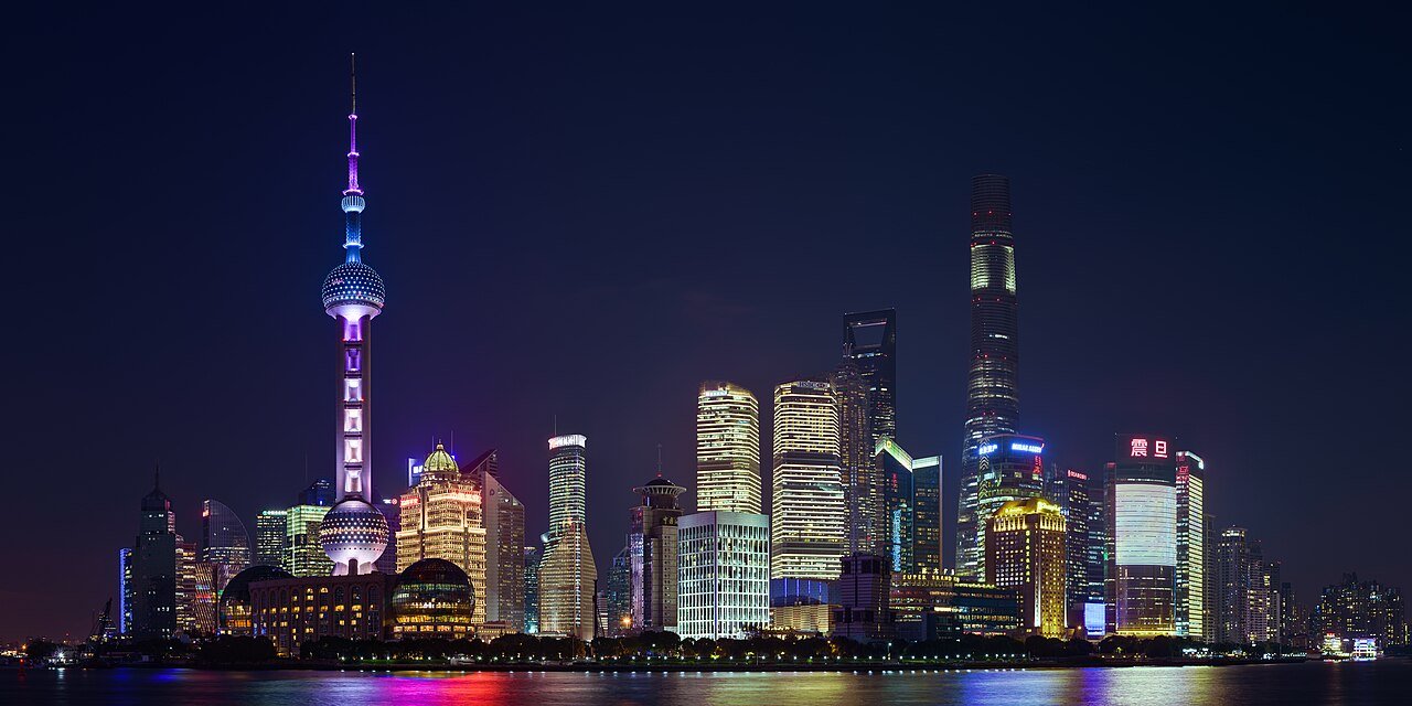Pudong Shanghai illuminated skyline and Bund riverfront from a rooftop terrace