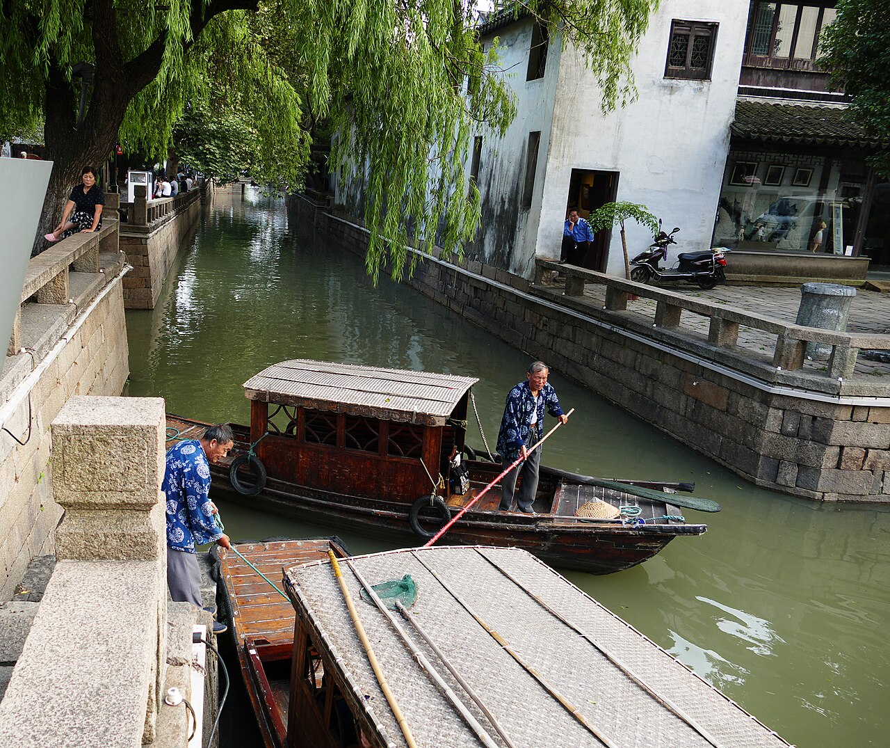 Wooden boats gliding down a traditional canal lined with whitewashed houses in Suzhou near Shanghai