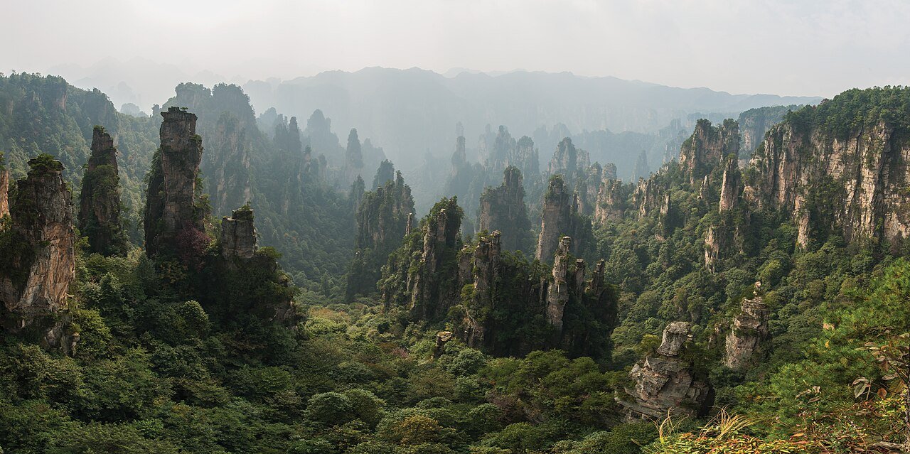 Jagged sandstone mountain spires and peaks veiled in mist at Tianzi Mountain in Zhangjiajie